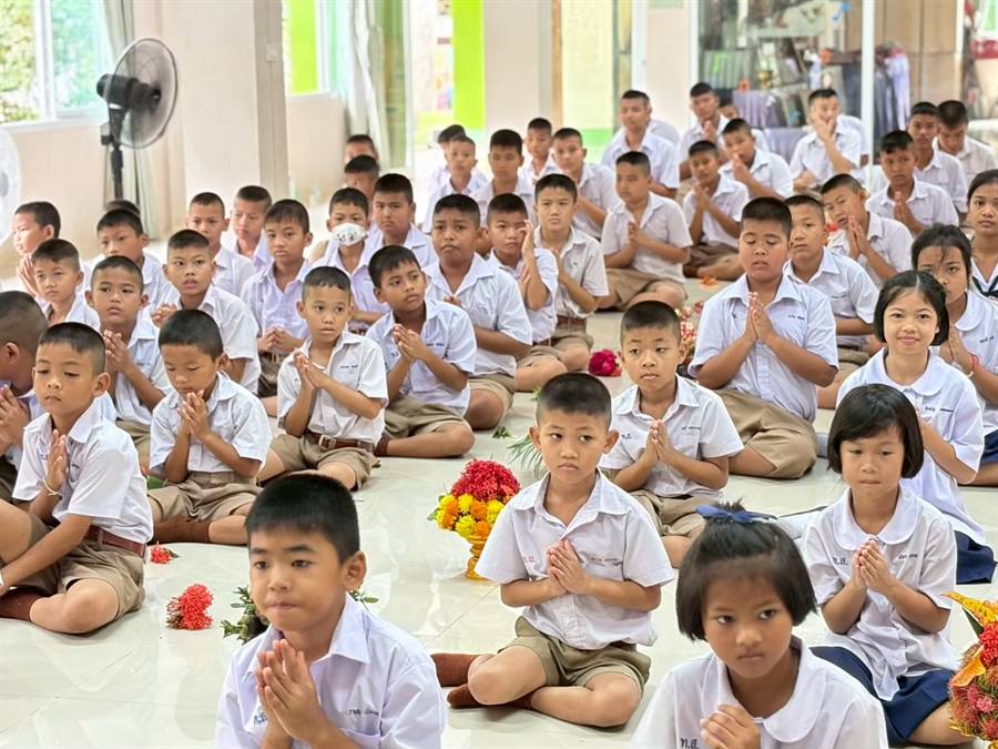 นักเรียนนั่งไหว้ครูพร้อมพานดอกไม้